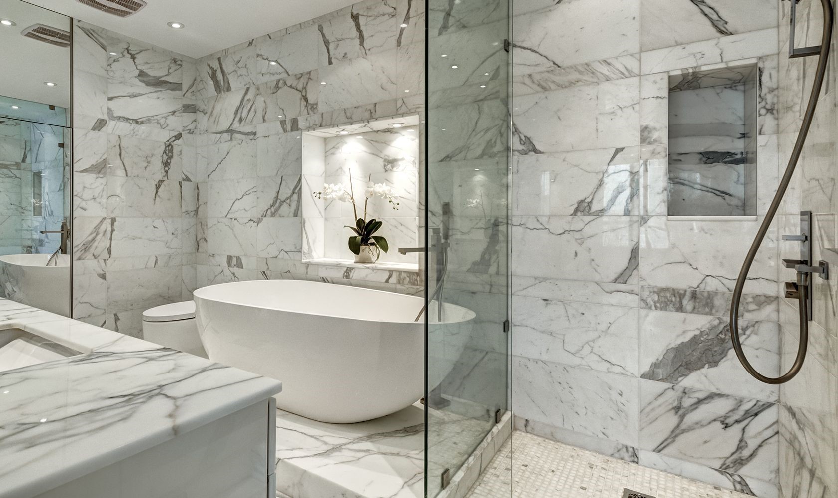 Marbled bathroom with custom glass shower and tub enclosures_cropped